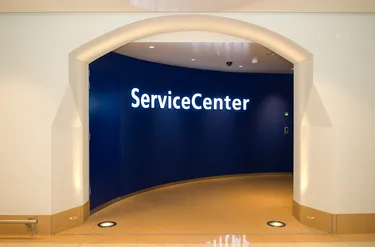 Een entree van een servicecentrum met een blauwe muur en witte boog, voorzien van een bord met de tekst Service Center.