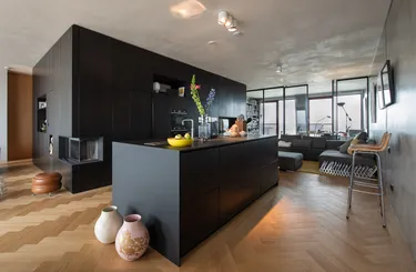 Een moderne woonkamer of lounge met donkere stijlvolle muren, een groot raam en een comfortabele zitgroep voor rust.